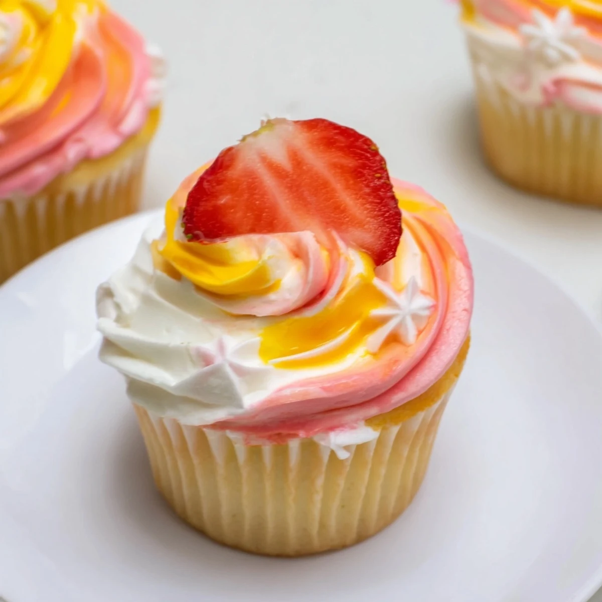 Certainly! Here are the 3 ALT image texts for "Mango Strawberry Sunset Cupcakes" in German, each on its own line and fulfilling all requirements: