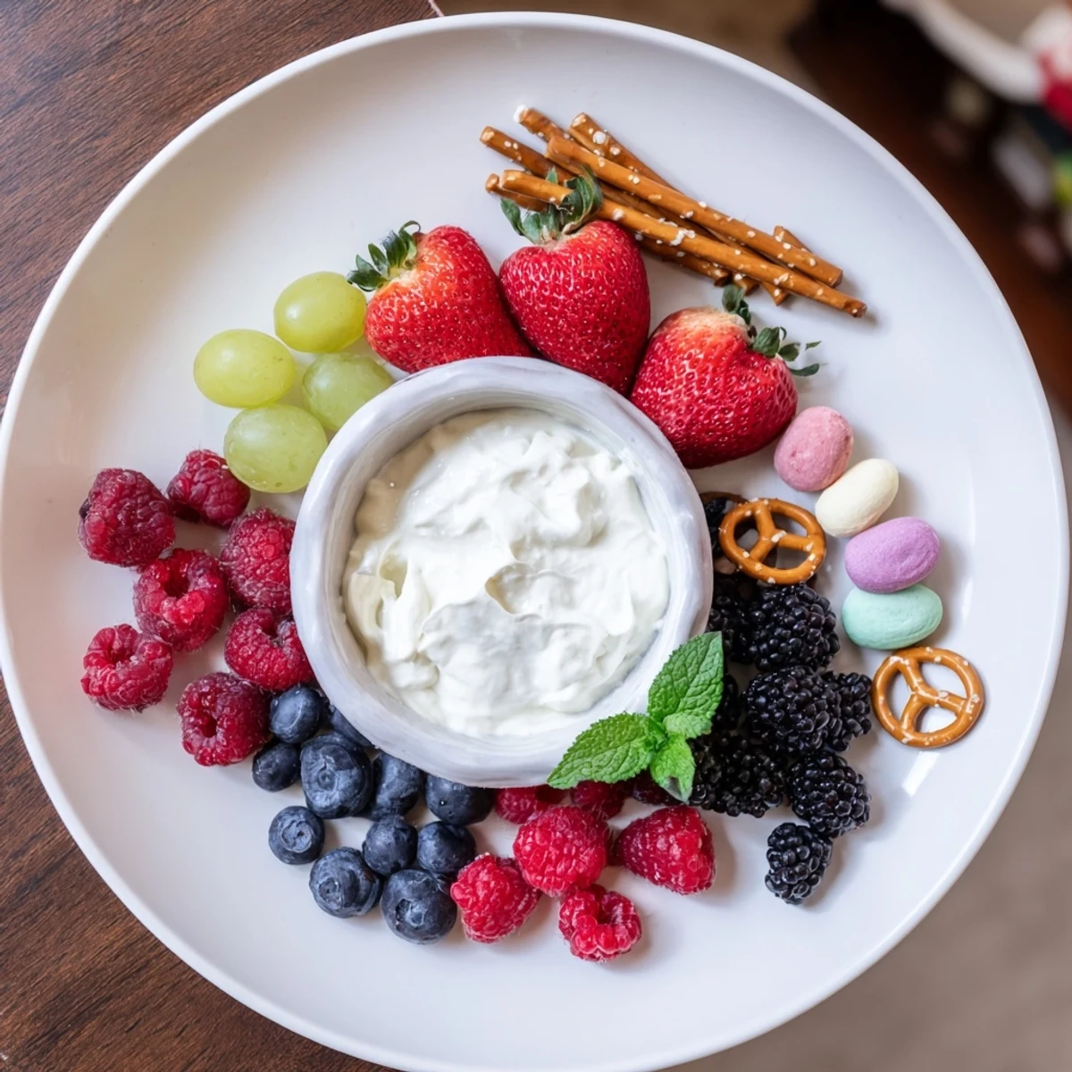 This Mistletoe Kiss Berry Dip Board showcases a luscious, chilled dip surrounded by colorful, juicy fruits.