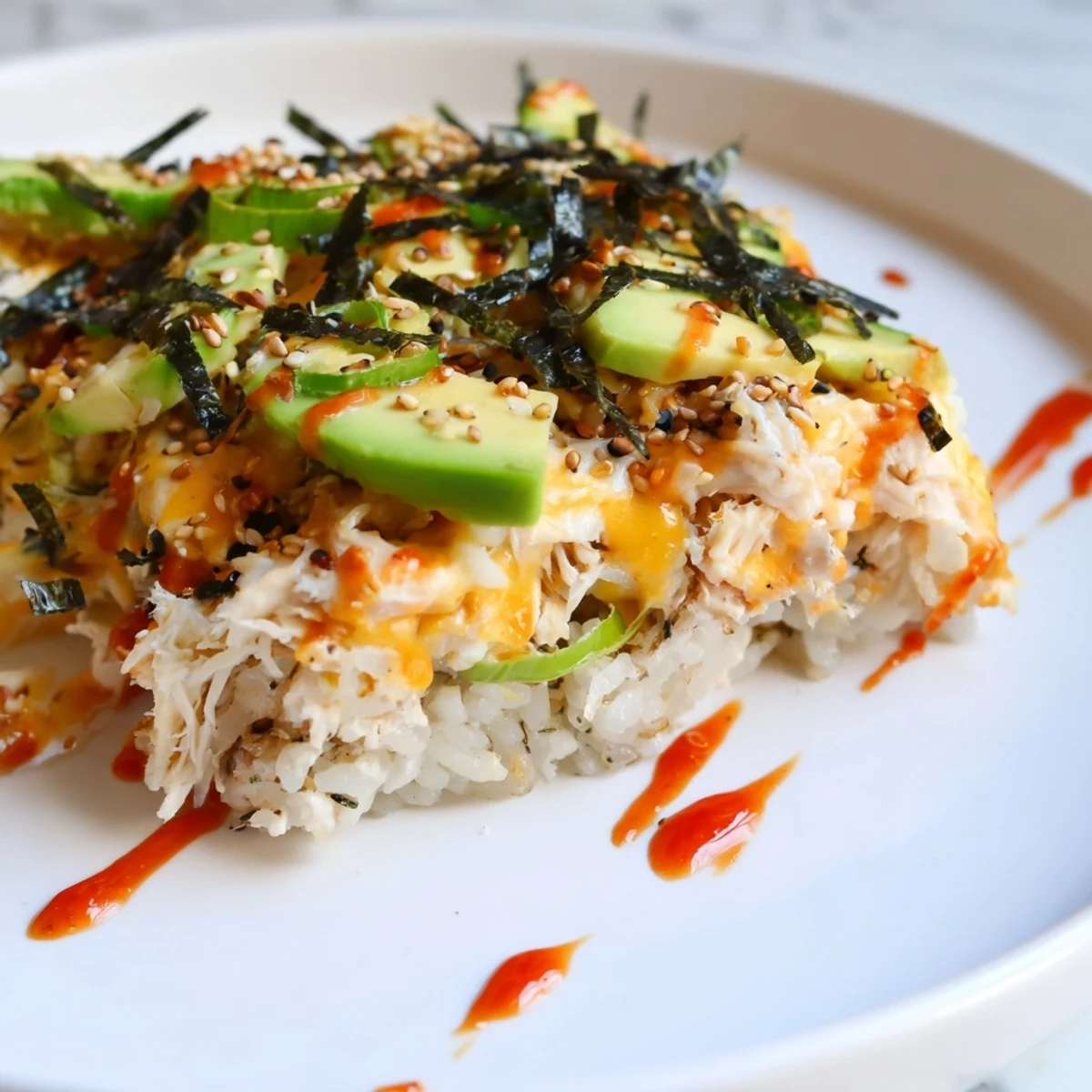 Creamy Chicken Sushi Bake with melted cheese and avocado, perfect for a flavorful meal.