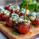 Kleine Caprese-Spieße mit Pesto-Drizzle: Frische Tomaten, cremiger Mozzarella und Basilikum, beträufelt mit hausgemachtem Pesto. Perfekt für Sommerpartys.