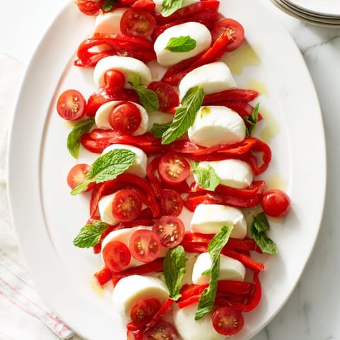A beautiful Peppermint Stripe Celebration platter with vibrant red berries and creamy white cheeses.