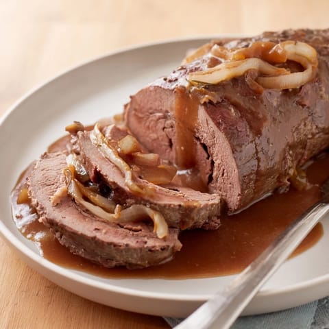 Traditionelle deutsche Rinderrouladen, serviert mit cremigem Kartoffelpüree und Rotkohl.  