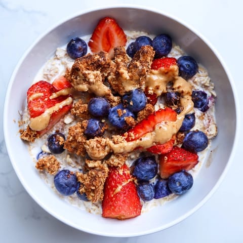 A close-up of overnight oats gourmet makeover, showcasing cookie crumbles and a nut butter swirl.