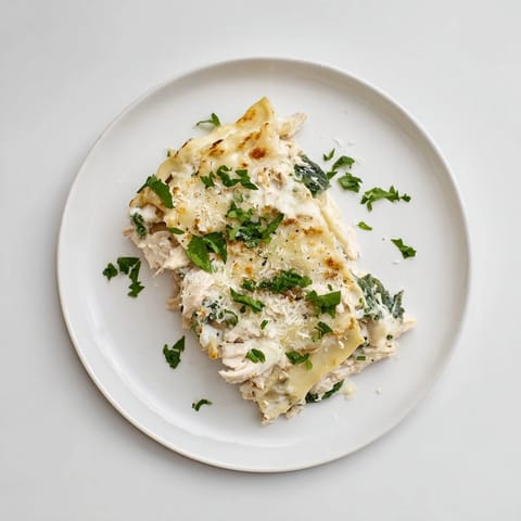 Ungedeckte Chicken Alfredo Lasagna mit cremiger Sauce, zartem Hähnchen und Goldener Mozzarella-Kruste im rustikalen Ofenblech.