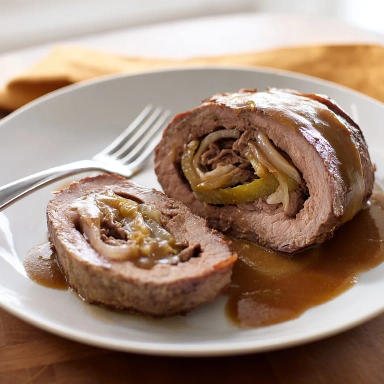 Leckere Rinderrouladen gefüllt mit Dillgurken und Zwiebeln in einer herzhaften Brühe.