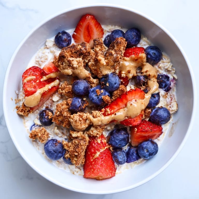 A close-up of overnight oats gourmet makeover, showcasing cookie crumbles and a nut butter swirl.