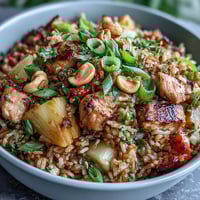 Hawaiian Pineapple Chicken Fried Rice mit saftiger Ananas, zartem Hühnchen und bunten Gemüsesorten in einer Pfanne.