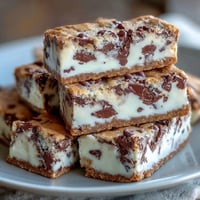 Süße, buttrige Keksriegel mit cremiger Clotted Cream und weißen Schokoladenstückchen. Perfekt für ein luxuriöses Dessert.